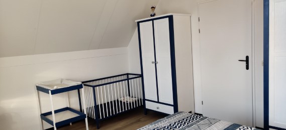 Grote slaapkamer met kinderbedje en verzorgingstafel